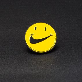 Nike Smile Pins, Smiley met Nike Swoosh als Mond, geel met zwarte speld 